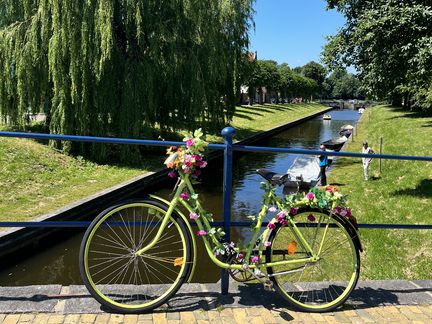 Bild: Ein geschmücktes Fahrrad auf der Steinbrück in Friedrichstadt. Im Hintergrund findet man die Grachten. 